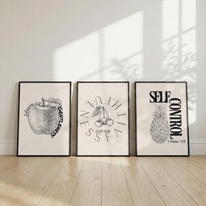 May include: Three framed art prints with black frames. The prints feature black and white illustrations of an apple, cherries, and a pineapple. Each print has a different inspirational word and Bible verse.