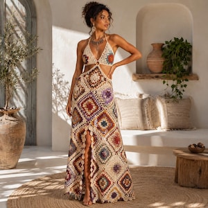 May include: A floor-length halter neck dress crafted from beige crochet granny squares in various colors including red, purple, and blue. The garment features a deep V-neckline, a cutout midriff, and a high front slit, showcasing a detailed geometric pattern throughout the entire piece.