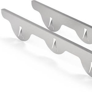 May include: Two silver-colored metal brackets with a curved design and cut-out sections. The brackets are positioned diagonally, suggesting they are for mounting or support. The overall design is modern and minimalist.