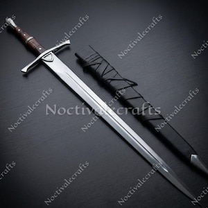 May include: A long, silver sword with a brown wooden handle and a crossguard. The sword is next to a black leather sheath. The blade is sharp and the handle is detailed. The sword is a medieval style weapon.