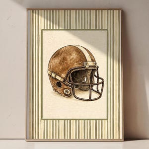 May include: Watercolor painting of a vintage football helmet. The helmet is brown with a white stripe down the center and a dark brown face mask. The artwork is framed with a green border and a striped background.