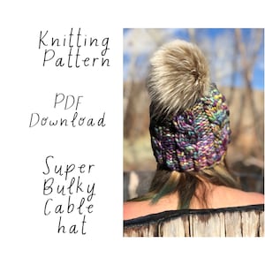 May include: Knitting pattern PDF download for a super bulky cable hat with a faux fur pom pom. The hat is a mix of purple, blue, and green yarn.