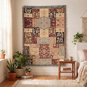Peut inclure: Un plaid tissé rectangulaire présentant un motif patchwork de fleurs et d'ornements dans des tons rouge foncé, crème, noir et bleu clair, fini avec une bordure à franges en haut et en bas, présenté suspendu sur un mur.