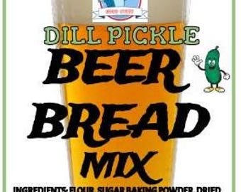Könnte beinhalten: Ein Glas Dill-Pickle-Bierbrotmischung mit dem Text "DILL PICKLE BEER BREAD MIX". Das Bild enthält eine Cartoon-Gurkenfigur und den Text "GOOD STUFF" oben. Die Zutaten sind unten aufgeführt.