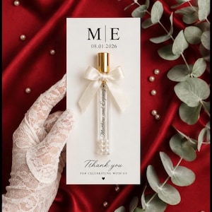 May include: A rectangular white card featuring the letters M|E, the date 08.01.2026, and the text Thank you FOR CELEBRATING WITH US. A clear glass vial with a gold cap, a cream satin bow, and the text Matthew and Enjoying is attached to the card.