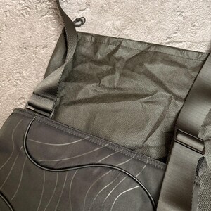 Peut inclure: Sac messager gris fonc&eacute; avec un motif de vagues et une bandouli&egrave;re. Le sac a une fermeture &agrave; rabat et un petit logo sur le devant. Le sac est fait d'un mat&eacute;riau durable et a un design simple et moderne.