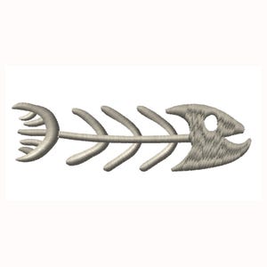 Könnte beinhalten: Detaillierte Stickerei eines Fischskeletts in neutralem Beige. Das Design zeigt einen Kopf mit Auge und Mund, eine zentrale Wirbelsäule und gebogene, rippenartige Strukturen. Die Stickerei befindet sich auf weißem Hintergrund.