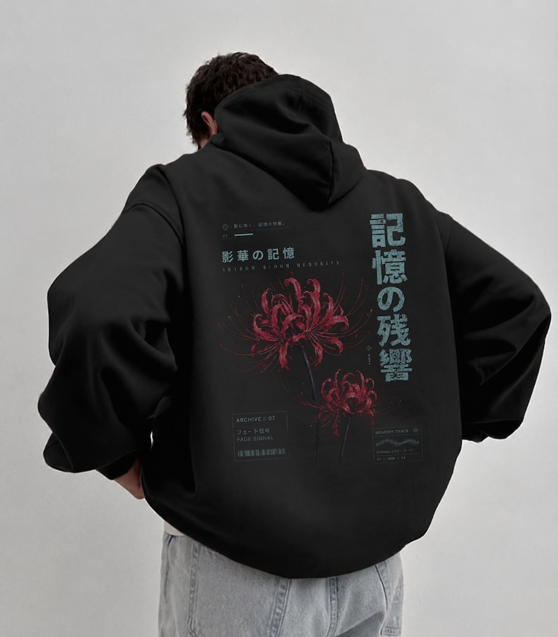 May include: A black hooded sweatshirt featuring a graphic on the back with two red spider lily flowers. The design includes Japanese text, the English words "FADE SIGNAL" and "MEMORY TRACE," and small geometric symbols in a light blue color.