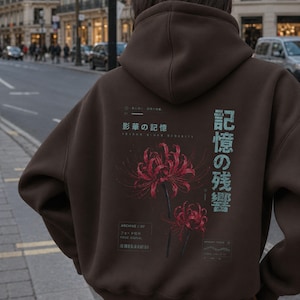 May include: A dark brown hooded sweatshirt featuring a graphic print on the back. The design includes two red spider lily flowers, Japanese text, and smaller English text elements including "ARCHIVE 07" and "FADE SIGNAL" in a technical layout.