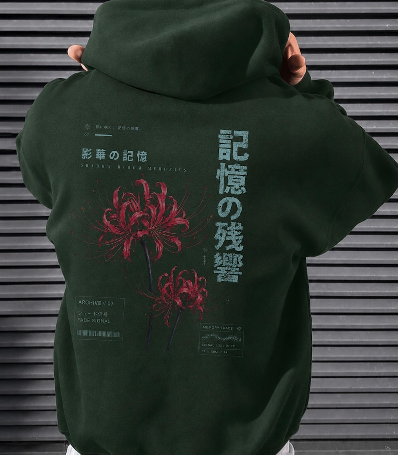 May include: A dark forest green hooded sweatshirt featuring a graphic on the back. The design includes two red spider lily flowers, Japanese text, and smaller English text elements including "Archive // 07", "Fade Signal", and "Memory Trace".