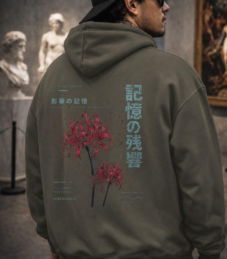 May include: An olive green hooded sweatshirt featuring a graphic on the back with two red spider lily flowers, light blue Japanese text, and smaller white text including the words Archive 07 and Fage Signal printed in a clean layout.