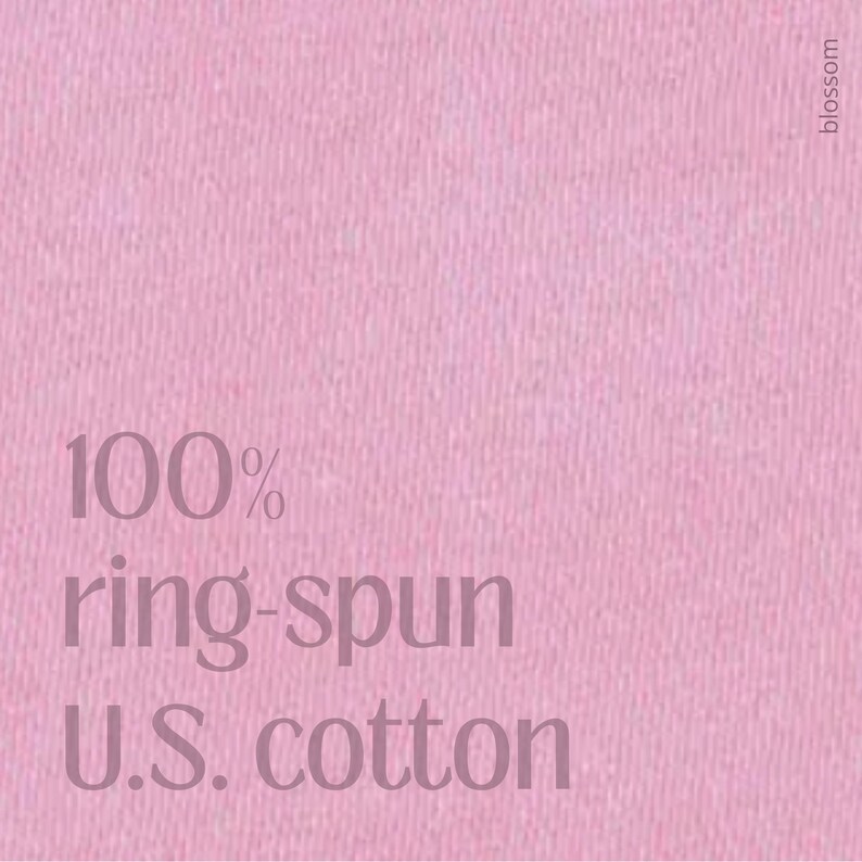 Peut inclure: Gros plan sur un tissu rose avec le texte "100% ring-spun U.S. cotton" dans une police rose plus fonc&eacute;e. Le mot "blossom" est imprim&eacute; verticalement en haut &agrave; droite.