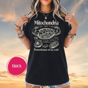 May include: Black t-shirt with a white graphic design featuring the word "Mitochondria" and an illustration of a cell. The text "Powerhouse of The Cell!" is also included in the design.