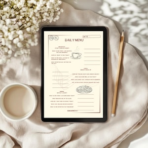 Könnte beinhalten: Ein digitales Tagesmenü auf einem Tablet mit beigem Hintergrund. Das Menü enthält Abschnitte für Frühstück, Mittagessen und Abendessen mit Aufforderungen zur Reflexion. Ein Bleistift und eine Tasse liegen neben dem Tablet. Der Text "DAILY MENU" ist sichtbar.