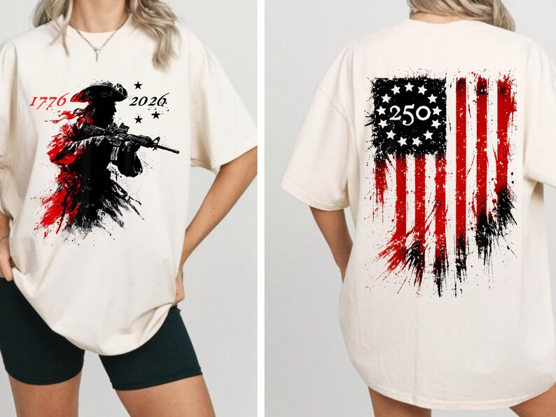 以下が含まれることがあります： クリーム色のTシャツ。ライフルを持った兵士のグラフィック、赤と黒のペイントスプラッター、数字の「1776」と「2026」が特徴です。背中には、数字「250」が付いた、使い古されたアメリカ国旗のデザインが表示されています。