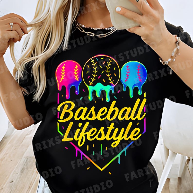 May include: Black t-shirt with a colorful graphic design. The design features three baseballs with dripping paint effects in pink, yellow, and blue. The text "Baseball Lifestyle" is in a yellow, stylized font.