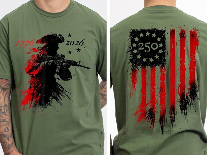 以下が含まれることがあります： オリーブグリーンのTシャツ。ライフルを持った兵士のグラフィック、数字の「1776」と「2026」、星が描かれています。背中には、数字「250」が入った、使い古されたアメリカ国旗のデザインが施されています。