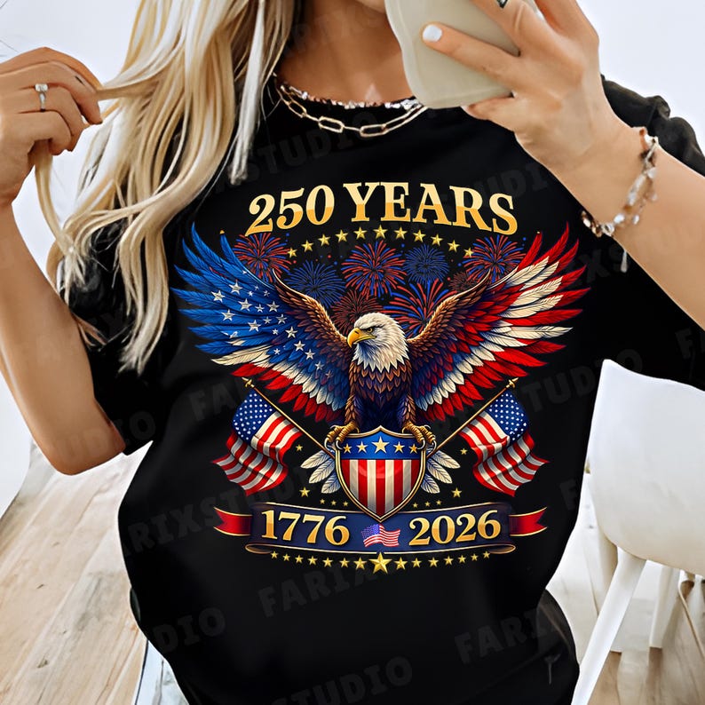 May include: Black t-shirt featuring a patriotic design with an eagle, American flags, and fireworks. The shirt displays the text "250 YEARS", "1776", and "2026", celebrating a historical milestone. The eagle's wings are colored in the American flag's colors.