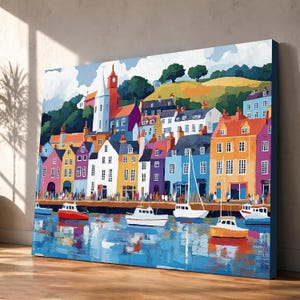 May include: A rectangular canvas print featuring a colorful harbor scene with multi-story buildings in shades of yellow, orange, blue, and white. Several small boats float on the water in the foreground, reflecting the vibrant town architecture.