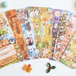 May include: A set of rectangular paper savings challenge trackers featuring colourful illustrations of animals and seasonal themes. The cards include text such as Seasonal Savings Challenges, Save 1K, Happy Easter, and various fillable fields for financial goals.