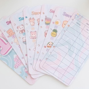 May include: A set of six punched paper savings challenge inserts featuring pastel pink and blue wavy backgrounds. Each sheet displays various cute illustrations like animals, food, and drinks, alongside numerical values and a grid table labelled Savings with columns for Challenge, Date, and Saved.