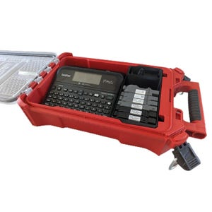 Puede incluir: Un maletín de transporte rojo de carcasa rígida que contiene una rotuladora Brother P-touch negra con teclado QWERTY y pantalla digital, junto a un compartimento negro con cinco cartuchos de cinta para etiquetas apilados.