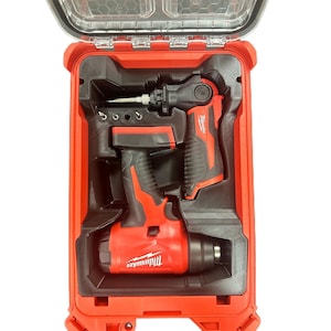 Puede incluir: Una pistola de calor inalámbrica y un taladro atornillador en ángulo recto de Milwaukee, en rojo y negro, guardados en un inserto de plástico negro moldeado dentro de un maletín rígido rojo. Las herramientas llevan el logo de Milwaukee.