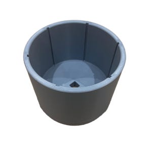 May include: A cylindrical gray container with a smooth exterior and a hollow interior. The inside features four vertical ridges spaced evenly along the walls, and the base contains a small, centered square-shaped opening for drainage or attachment.