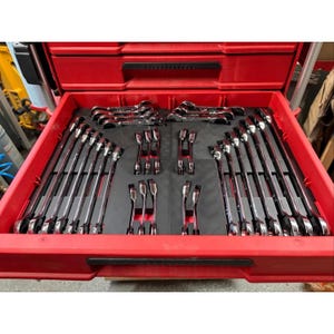May include: A bright red tool chest drawer containing a comprehensive set of chrome-plated combination wrenches organised in custom-fitted black foam inserts. The wrenches are arranged in rows and columns, showcasing various sizes and lengths.