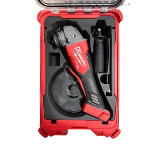 May include: A red and black Milwaukee Fuel cordless angle grinder with a circular grinding disc and a detachable side handle, securely stored inside a custom-fitted black foam insert within a durable red plastic carrying case with a clear lid.