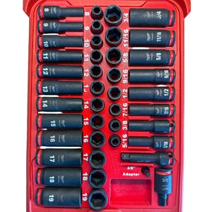 Puede incluir: Un estuche de herramientas rojo con tapa transparente, que contiene un juego de vasos de impacto negros y adaptadores. Los vasos están etiquetados con tamaños que van desde 7.9 mm a 19.05 mm. El estuche está bien organizado.