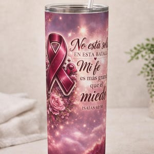 Puede incluir: Un vaso de acero inoxidable con un diseño de cinta rosa y el texto "No está sol en esta batalla Mi fe es más grand que el miedo ISAÍAS 41:10". El vaso tiene una pajita y un fondo de galaxia rosa y morado.