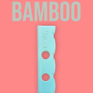 May include: A light blue rib tool with three circular cutouts and a curved edge, set against a coral background. The word "BAMBOO" is printed above the tool, and "Rib tool" is printed below.