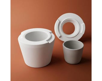 Puede incluir: Tres piezas de cerámica en tonos blanco y gris están dispuestas sobre una superficie marrón. La pieza más grande es un recipiente cilíndrico blanco con una amplia abertura. También hay una pieza circular blanca y una pequeña taza gris.