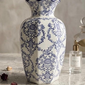 Può includere: Una tazza di ceramica bianca con manico nero e la scritta "But First, Coffee" in stile scritto a mano. La tazza è su una superficie bianca. La tazza è alta circa 10 cm.