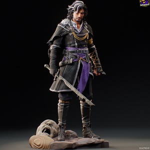 May include: A detailed figurine of a character in a black coat with purple accents, holding a sword. The figure has long dark hair with white streaks and is standing on a stone base with a carved face. The figure is wearing black boots and gloves.