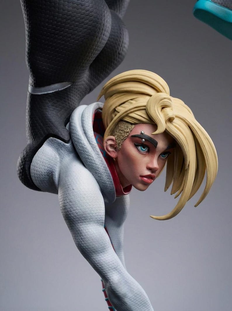 May include: A detailed figurine of a female character with blonde hair styled in a high ponytail. She wears a white and light blue hooded jacket with red accents. The figure has blue eyes and a piercing.