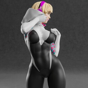 May include: A 3D-rendered figure of a female superhero in a black and white bodysuit with a spiderweb pattern. The figure has blonde hair, pink headphones, and a white hood. The figure is in a dynamic pose, with a gray background.