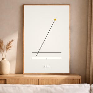 May include: A framed art print with a minimalist design. The artwork has a cream background with a black line and a yellow circle. The text "The Volley" is at the bottom of the print.