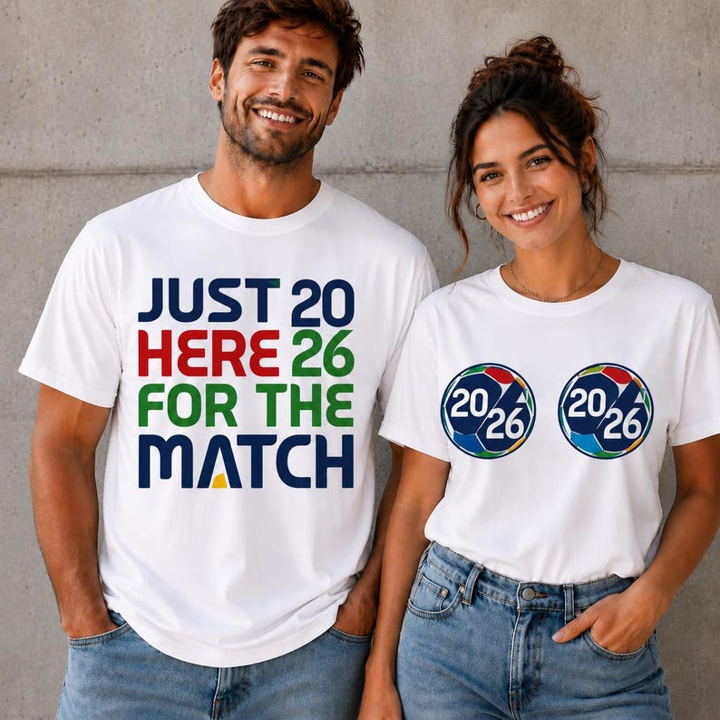 Puede incluir: Dos camisetas blancas. Una tiene el texto "JUST 20 HERE 26 FOR THE MATCH" en azul, rojo, verde y amarillo. La otra tiene dos gr&aacute;ficos de bal&oacute;n de f&uacute;tbol con "20/26" en su interior.