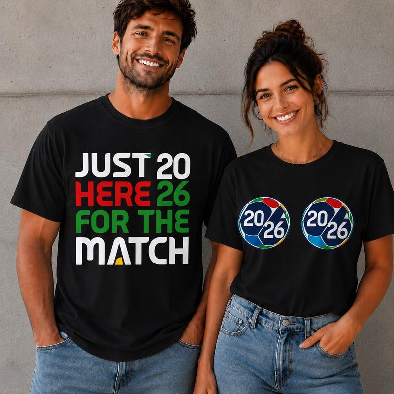 Puede incluir: Dos personas con camisetas negras. Una camiseta tiene el texto "JUST HERE FOR THE MATCH" en blanco, rojo y verde. La otra camiseta tiene dos gr&aacute;ficos de bal&oacute;n de f&uacute;tbol con "20/26" en su interior. Ambas camisetas son negras.