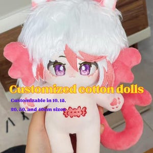 Puede incluir: Una muñeca de algodón con pelo blanco, orejas de gato rosas y una larga cola rosa. La muñeca tiene ojos morados, una pequeña criatura roja bordada en el pecho y huellas rosas en las manos. Texto: Shoppingful, Customized cotton dolls, Customizable in 10, 15, 20, 30, and 40cm sizes.