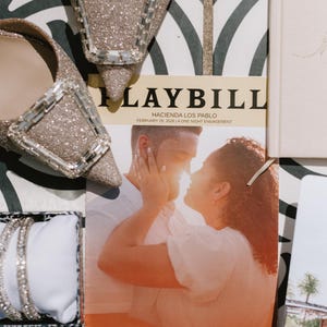 Könnte beinhalten: Ein Hochzeits-Stillleben mit einem Programm, einem Paar glitzernder Absätze und einem Armband. Das Programm enthält den Text "PLAYBILL" und "HACIENDA LOS PABLO FEBRUARY 28, 2026 | A ONE NIGHT ENGAGEMENT" und "THE WEDDING OF Megan & Joshua".