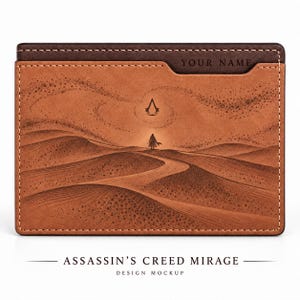 May include: A rectangular brown leather card holder featuring a desert landscape engraving with a central figure and the Assassin's Creed symbol. The top section includes a dark brown strip with the text YOUR NAME embossed in black.