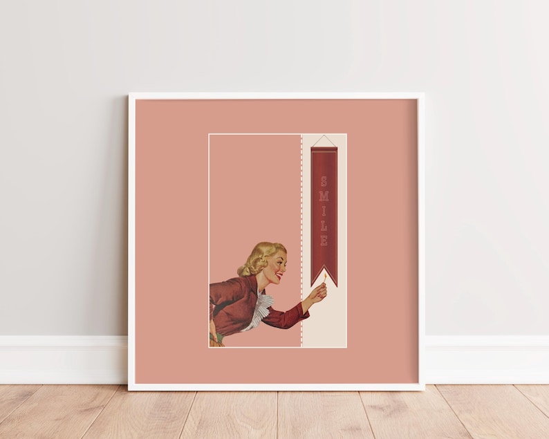 May include: A framed wall art print featuring a retro-style illustration of a person with blonde hair wearing a dark red jacket with a white ruffled collar. The person reaches toward a vertical dark red banner with the word SMILE printed in white.