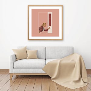 May include: A square framed wall art piece featuring a muted pink background with a central rectangular graphic. The graphic depicts a person in a maroon jacket reaching toward a vertical maroon banner containing the white text "SHINE".