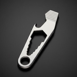 May include: A silver multi-tool with a bottle opener, hexagonal wrench, and a serrated edge. The tool has a key ring hole and a textured top. The tool is made of metal and is shown against a black background.