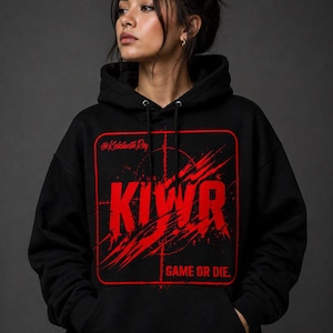 May include: Black hoodie with a red graphic design. The design includes the letters "KIWR" in a bold, distressed font, a target, and the phrase "GAME OR DIE." The text "@KickinwithRay" is also present. The hoodie has a drawstring hood and a front pocket.