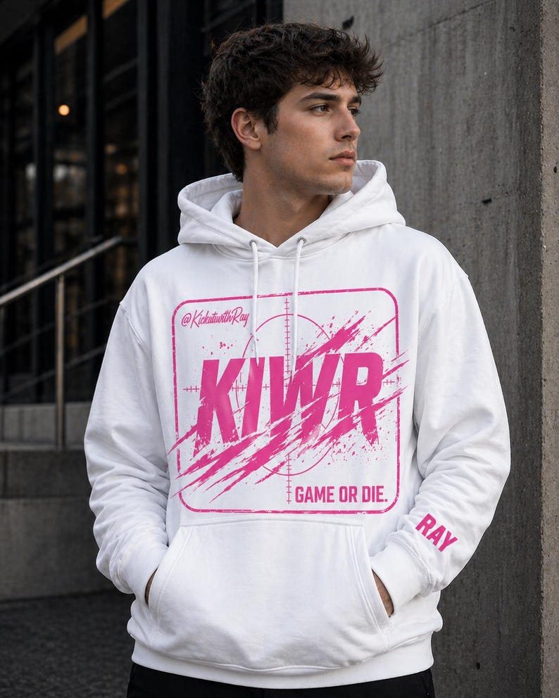 May include: White hoodie with a pink graphic that says "KIWR" inside a square with a target design and the words "GAME OR DIE." The sleeve has the name "RAY" printed on it. The hoodie has a front pocket and a hood.
