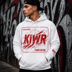 May include: White hoodie with a red graphic that says "KIWR" inside a rectangular target design. The hoodie has a drawstring hood and a front pocket. The text "GAME OR DIE" is below the graphic, and "RAY" is on the sleeve.